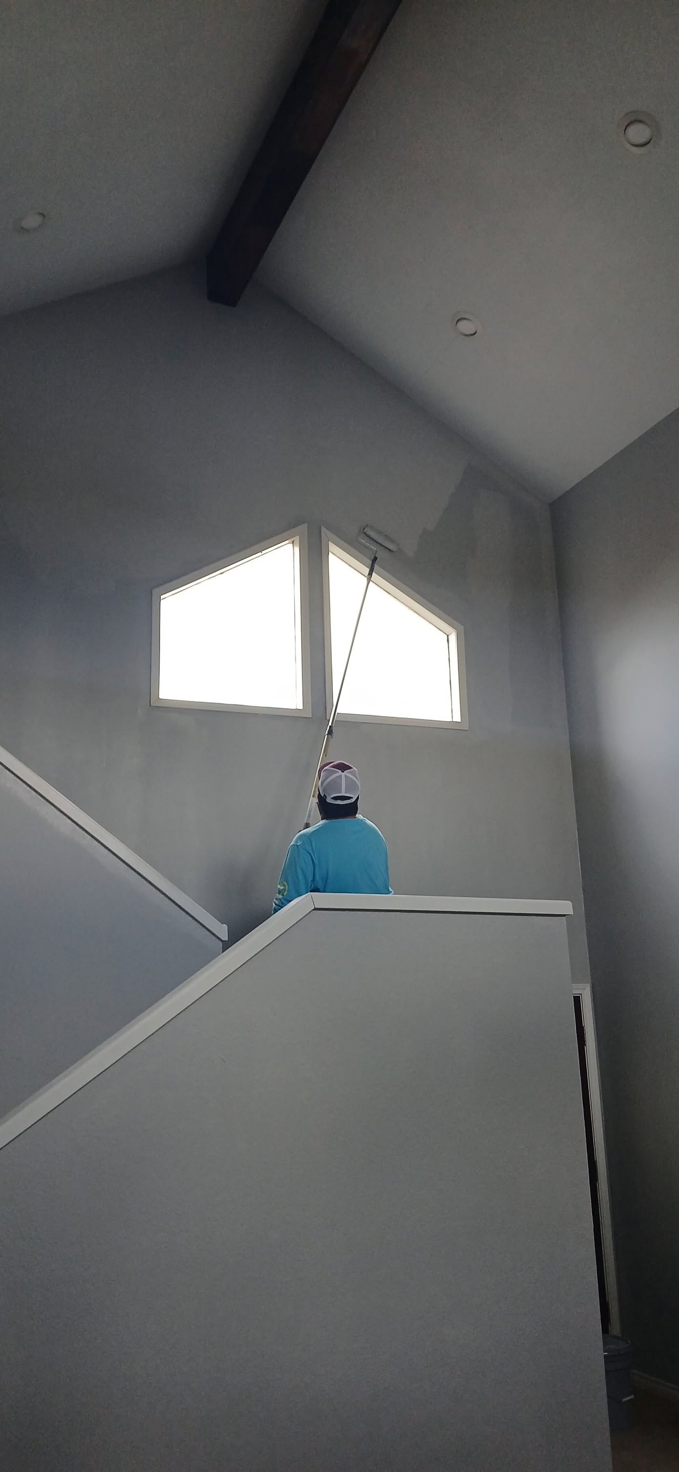 Comfort Homes painter finishing a vaulted ceiling